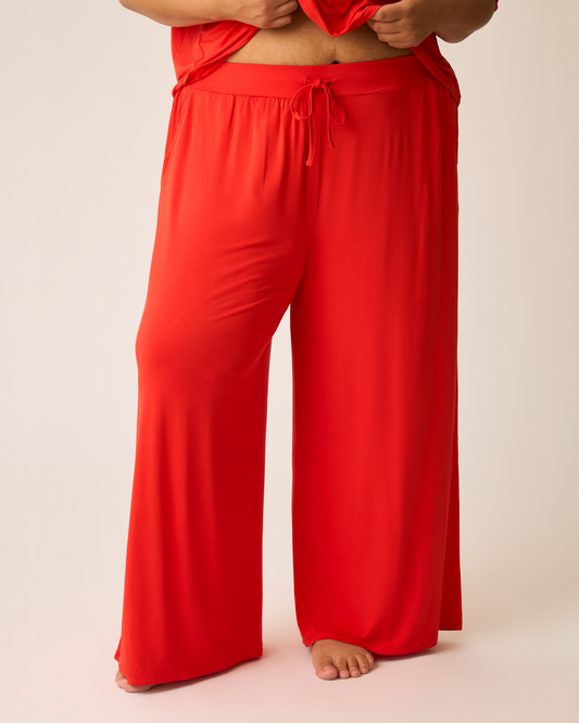 Bright red Aria lounge pants worn by a person on a beige background@model_info:Ionna is 5'11" and wearing a 2X.