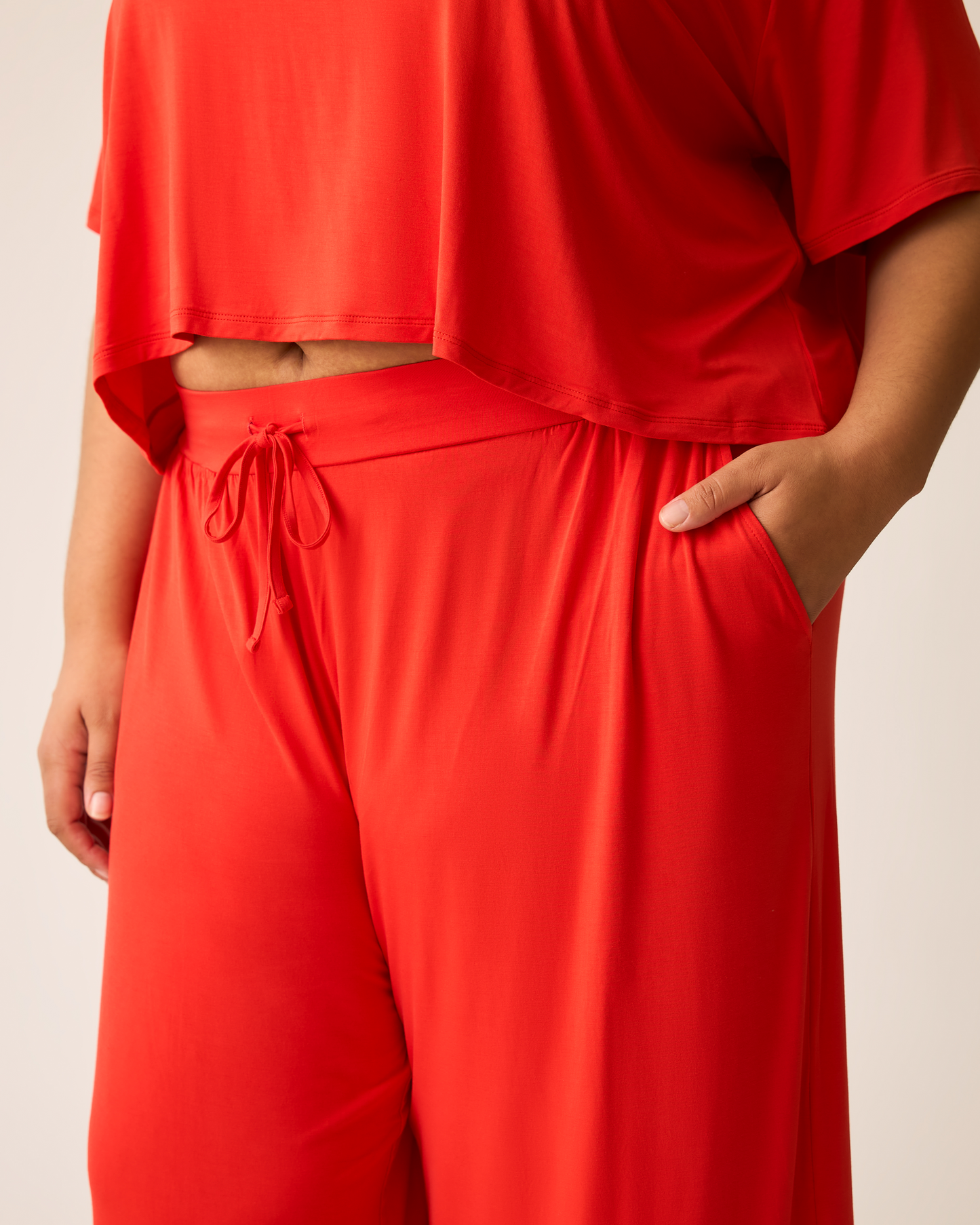 Person wearing a bright red Aria outfit with a plain background