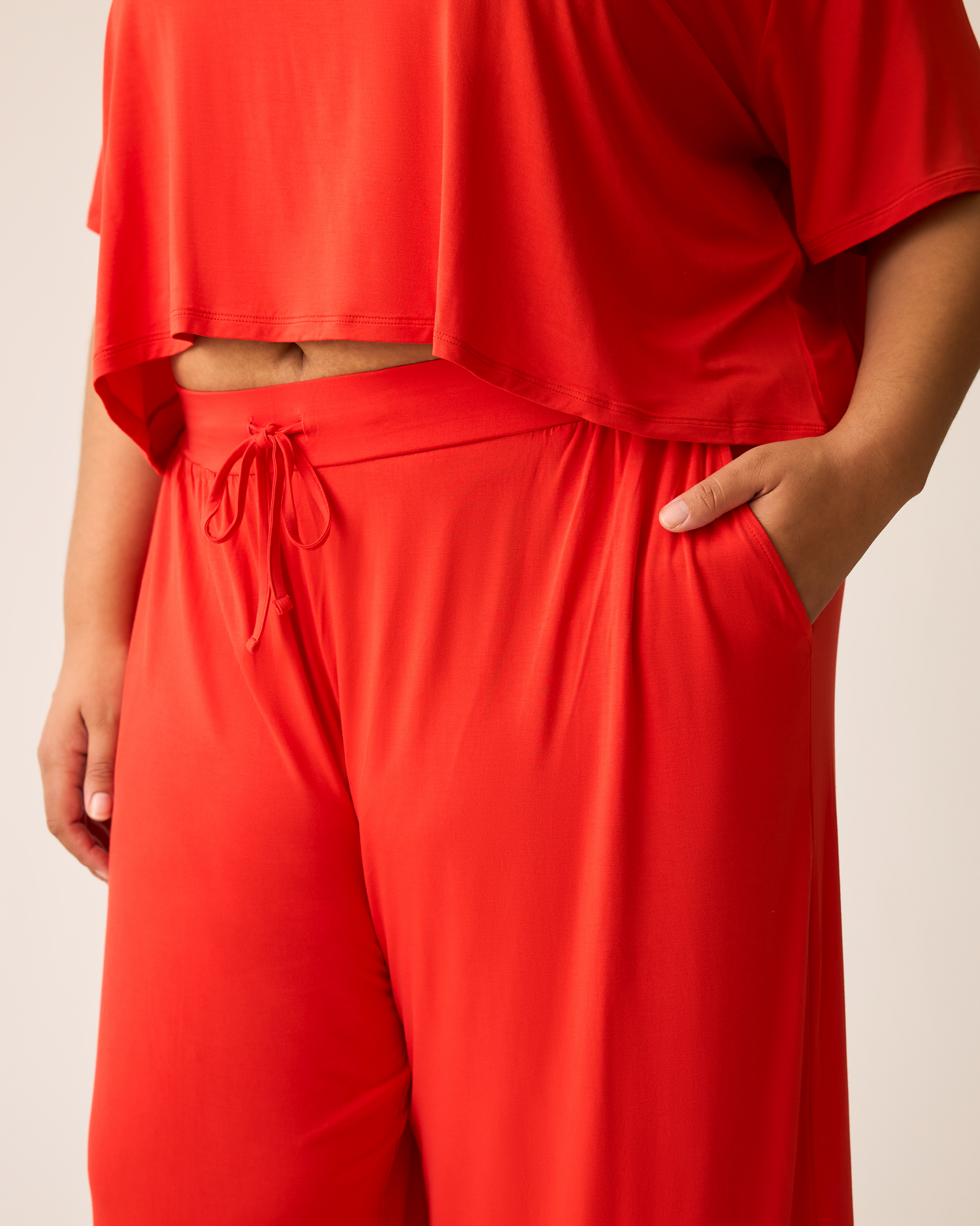 Person wearing a bright red Aria outfit with a plain background