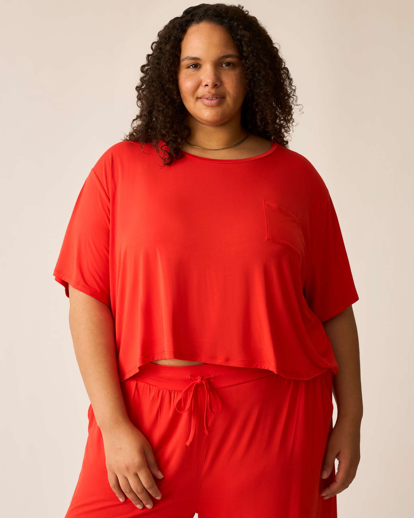 Woman wearing the Aria Short Sleeve Top in Bright Red @model_info:Ionna is wearing a 2X.