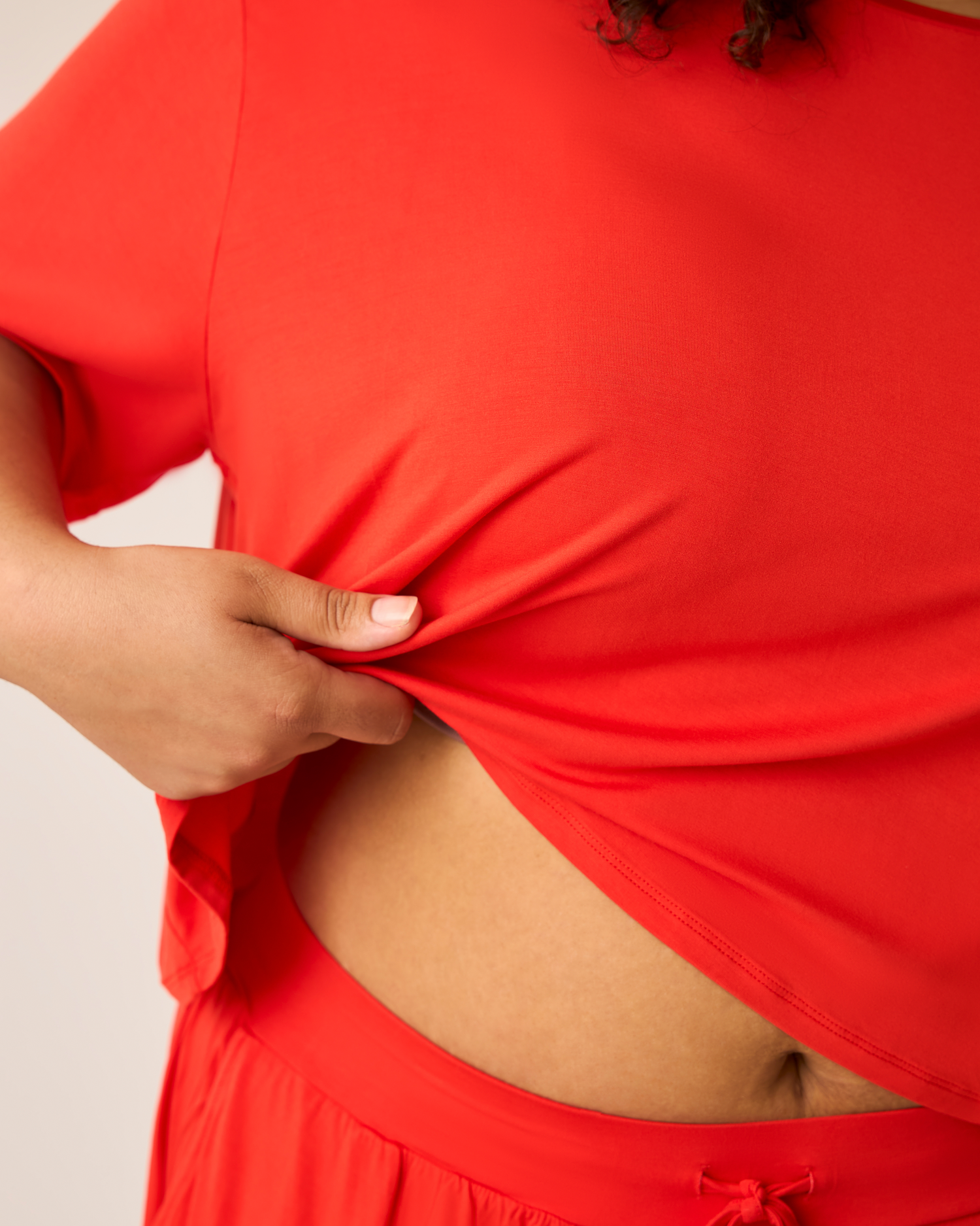 Person wearing a bright red Aria outfit with a plain background