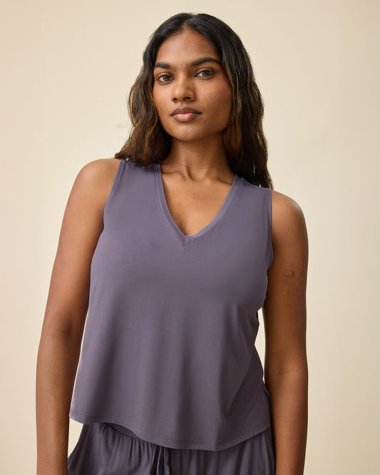 Model is wearing Aria Bamboo Cropped V-neck Tank in Granite and Aria Bamboo Casual Lounge Pant in Granite on a beige background.@model_info:Sahana is wearing a Small.