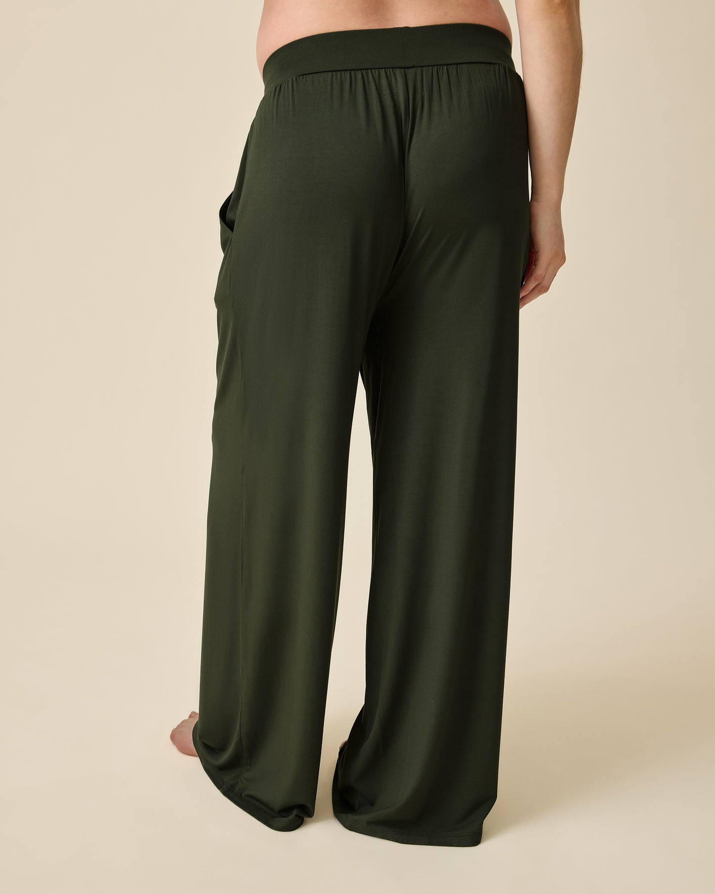 Back view of model wearing Aria Bamboo Casual Lounge Pant in Thyme on a beige background.