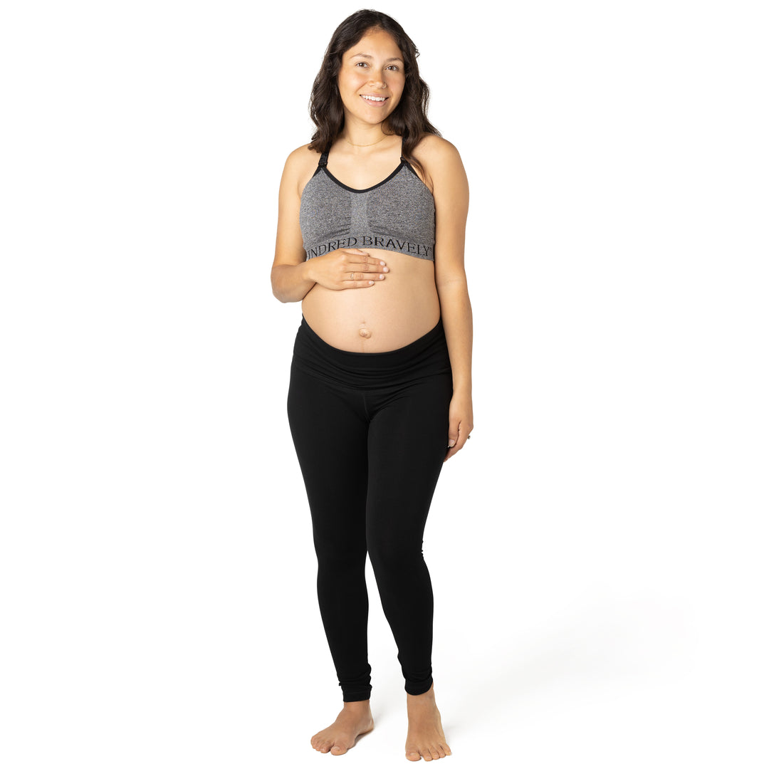 Front view of pregnant model wearing the Cotton Maternity & Postpartum Footless Tight in black, with  Sublime® Nursing Sports Bra in  heather grey