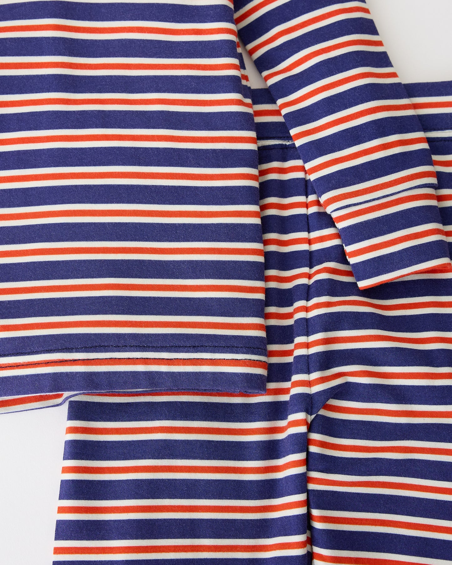 Close up of Bamboo Baby Two-Piece Pajama Set in Preppy Stripe on a beige background