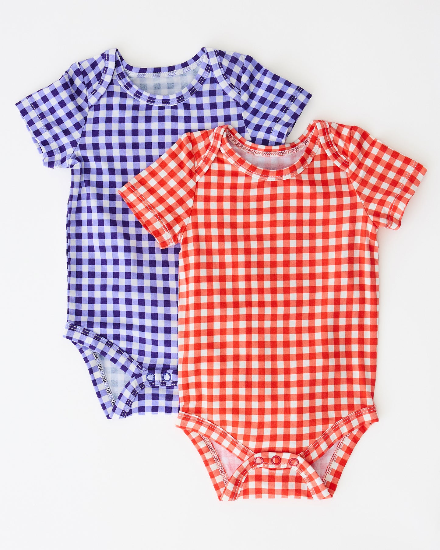 Baby Onesie Two-Pack in Red & Blue Gingham on a beige background