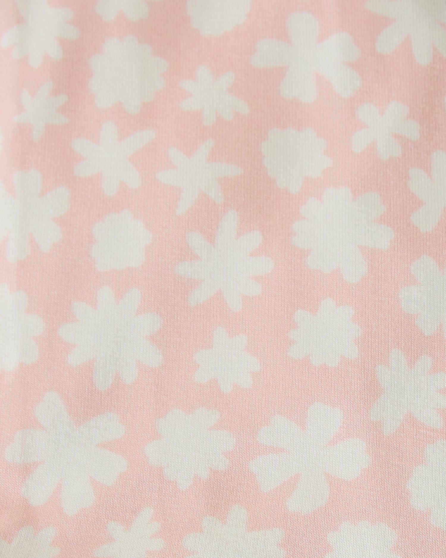 Close up swatch of Pink Chamomiles pattern of Baby Onesie Two-Pack in Cream & Pink Chamomiles on a beige background