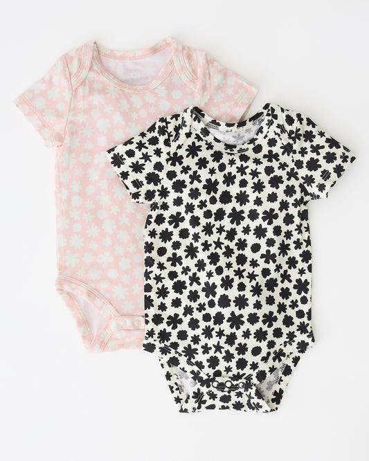 Baby Onesie Two-Pack in Cream & Pink Chamomiles on a beige background