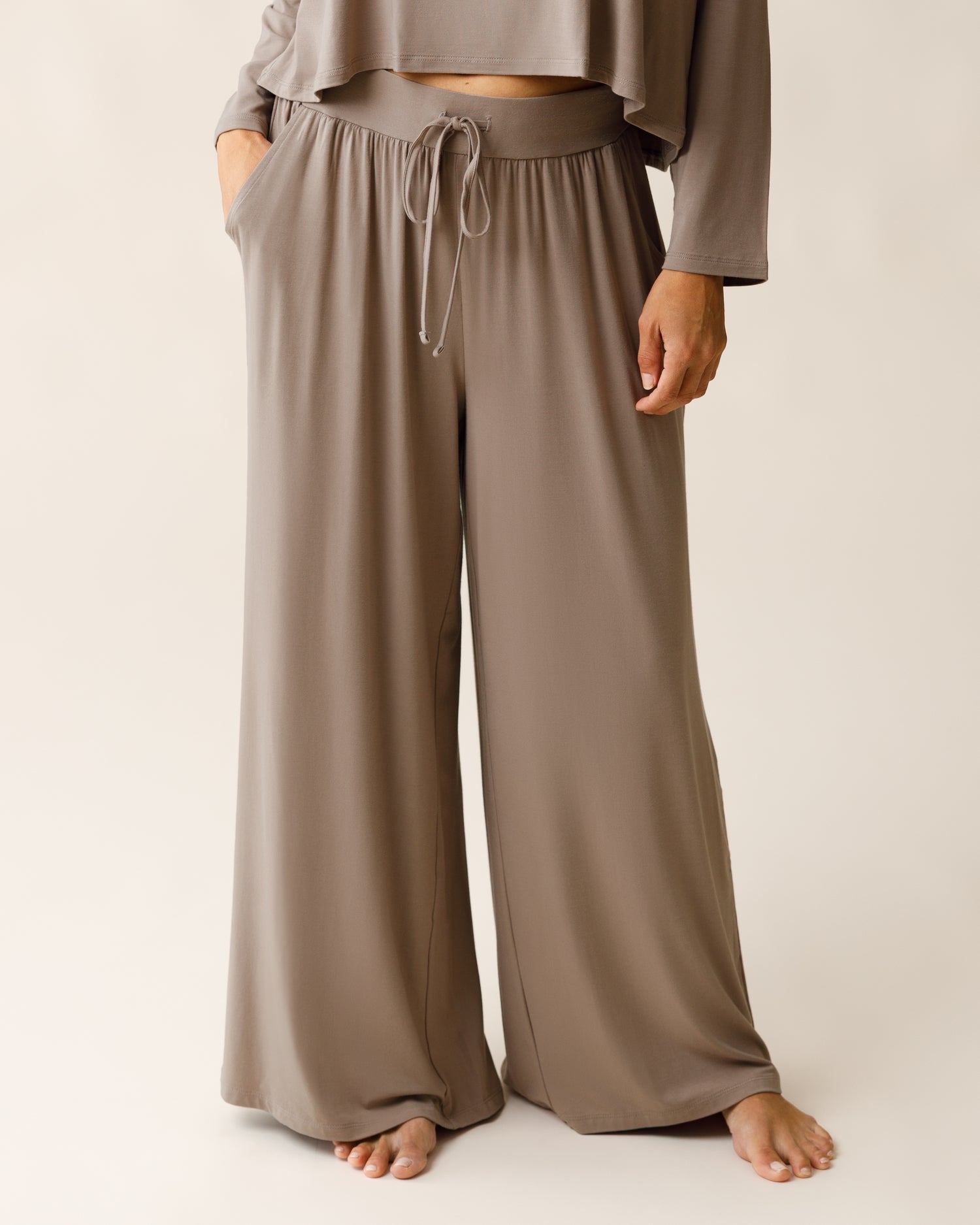 Woman wearing the Aria Bamboo Casual Lounge Pant Taupe, with one hand in a pocket, and paired with a matching top