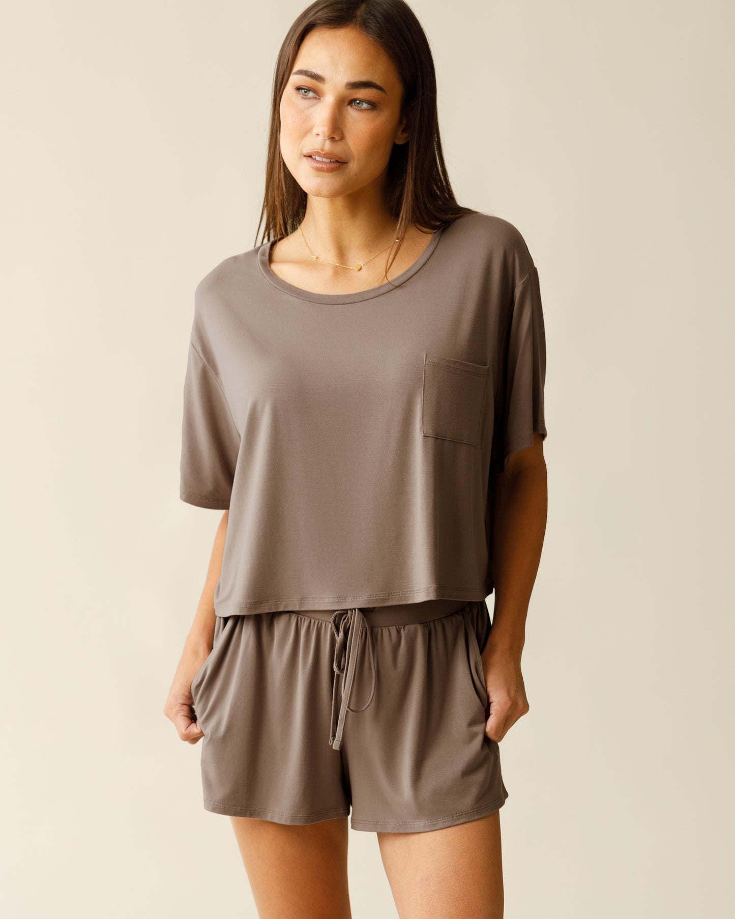 Woman wearing the Aria Bamboo Casual Cropped Short Sleeve Top in Taupe, paired with matching Aria Bamboo Casual Lounge Short, with hands in pockets@model_info:Lisa is 5'6" and wearing a Small.