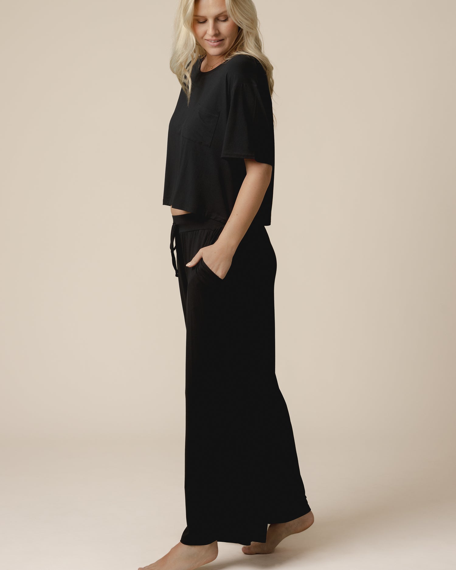 Side view of model wearing the Aria Bamboo Casual Cropped Short Sleeve Top in Black, paired with matching Aria Bamboo Casual Lounge Pant