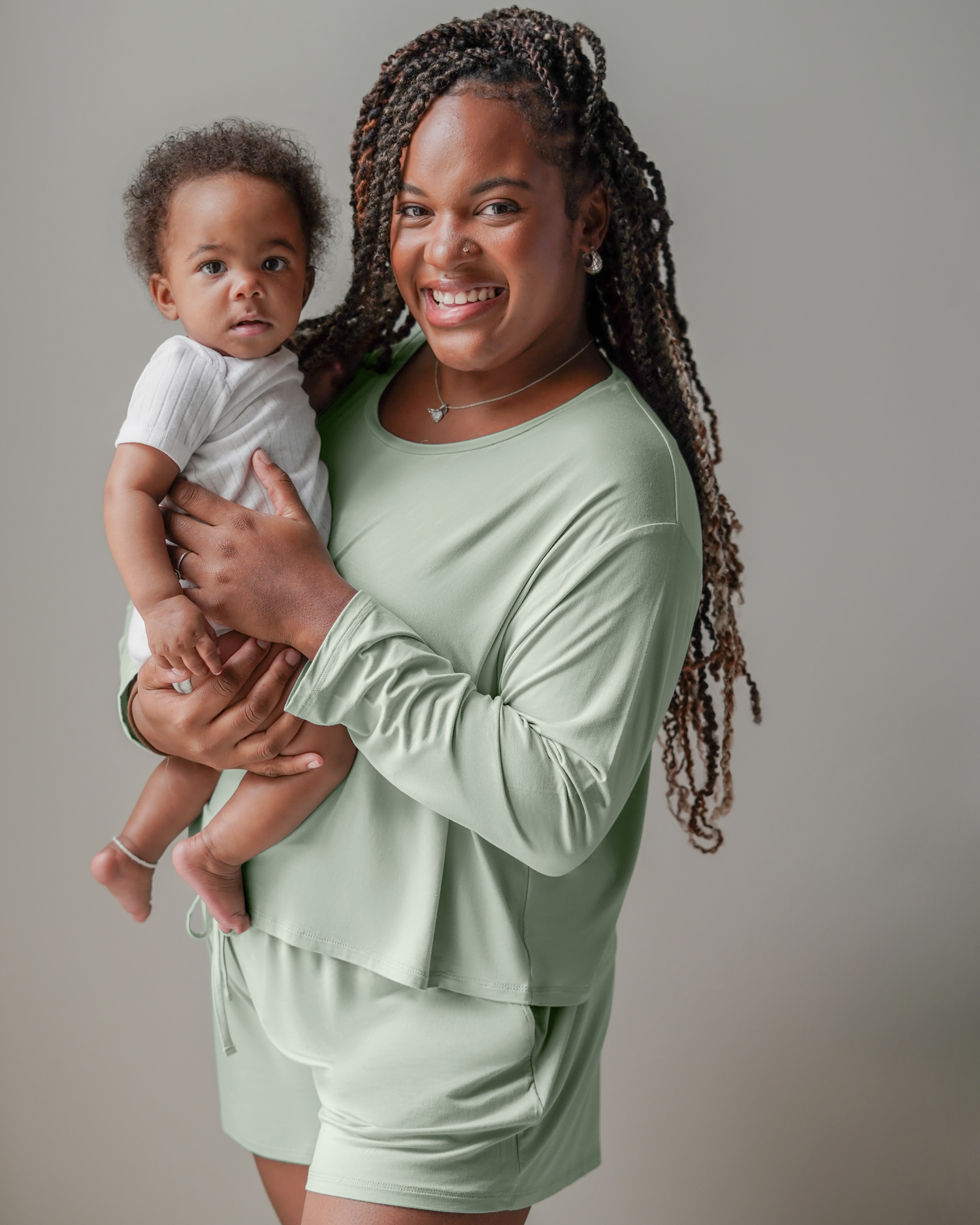 Model holding baby and wearing the Aria Bamboo Casual Lounge Short in Aqua Mist, paired with matching Aria Bamboo Casual Cropped Long Sleeve Top