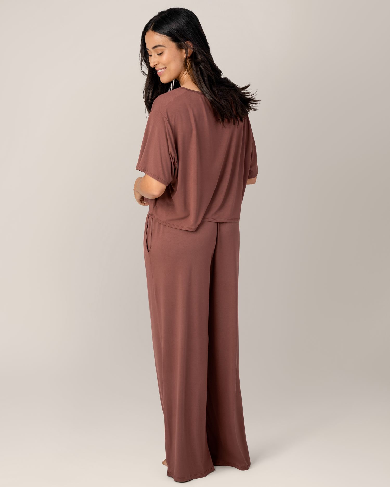 3/4 back view of model wearing the  Aria Bamboo Casual Lounge Pant in Redwood, paired with matching Aria Bamboo Casual Cropped Short Sleeve Top