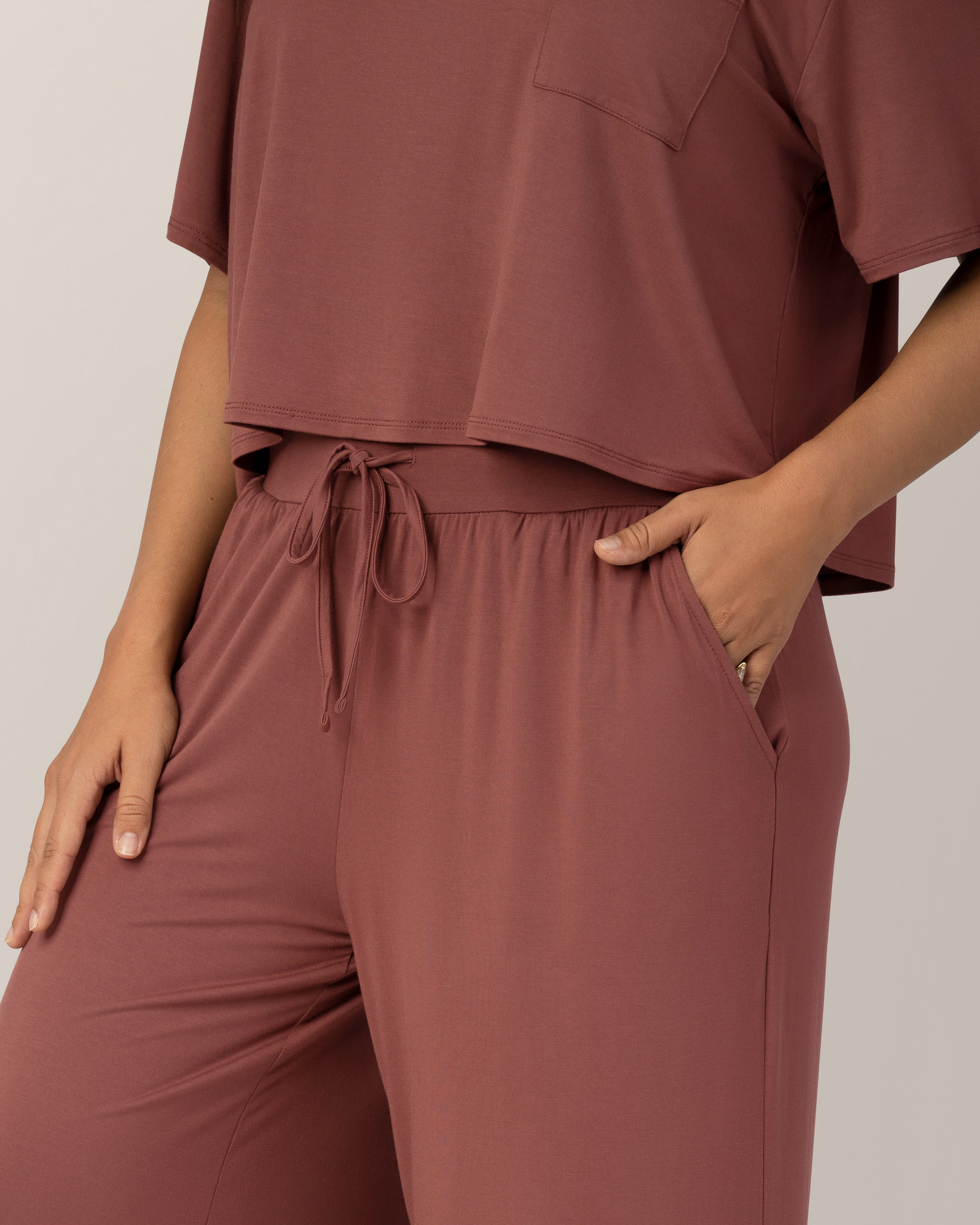 Close up of model wearing the  Aria Bamboo Casual Lounge Pant in Redwood, paired with matching Aria Bamboo Casual Cropped Short Sleeve Top, highlighting waistband and pocket detail on pants