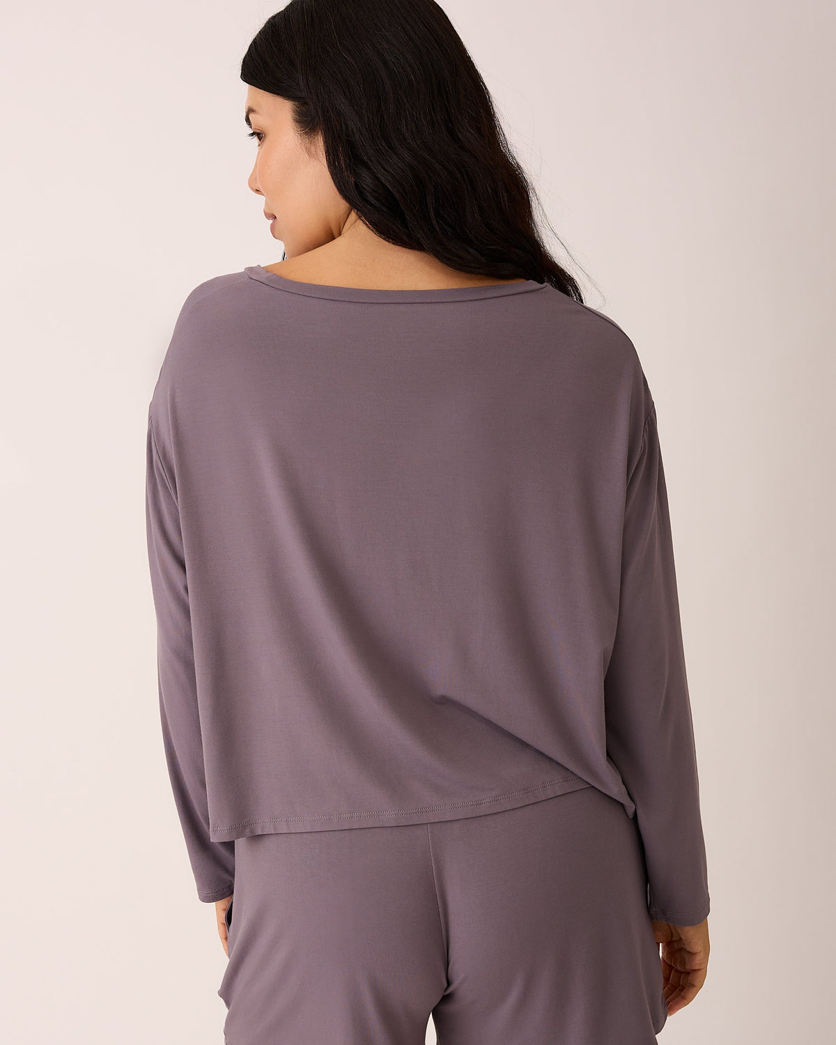 Back view of model wearing Aria Bamboo Casual Cropped Long Sleeve Top in Granite and Aria Bamboo Casual Lounge Short in Granite on a beige background.