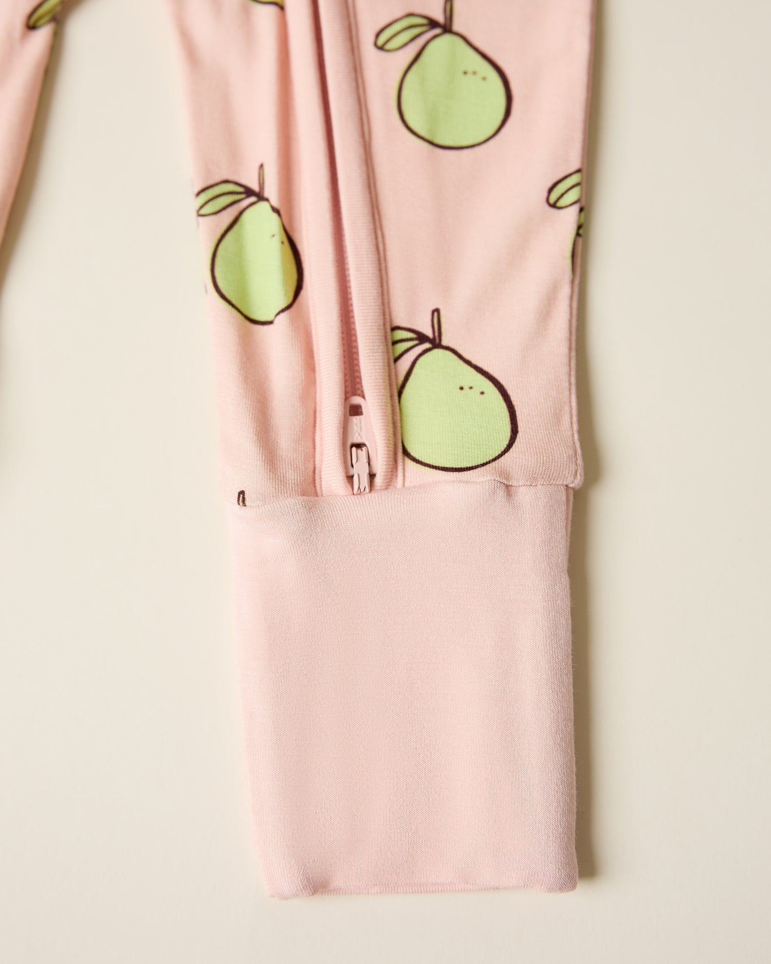 Bamboo Baby Pajama in pink pomelo, showing zipper detail on beige background