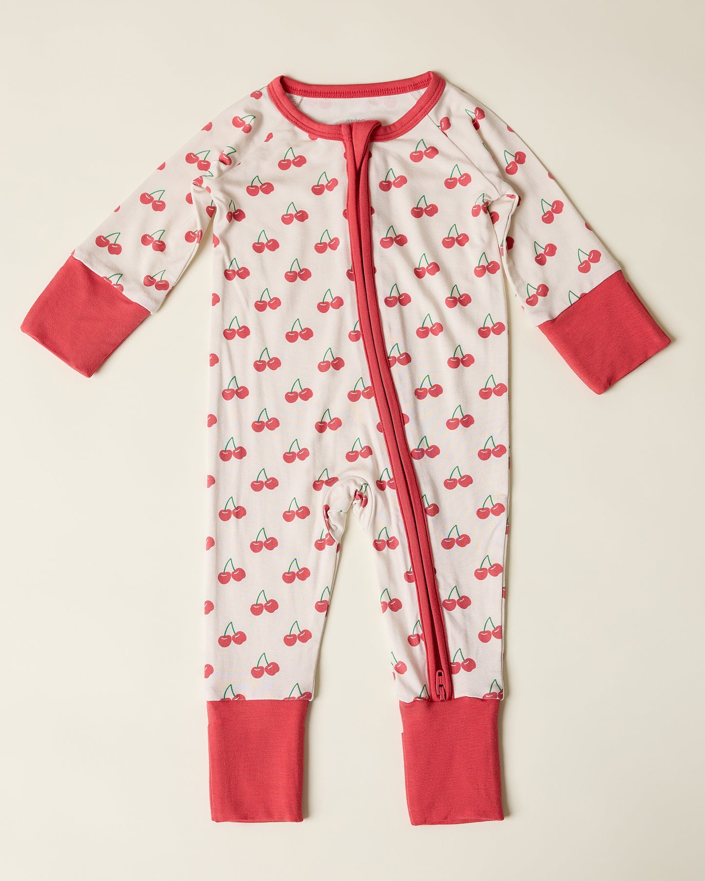 Bamboo Baby Pajama with cherry pattern on a beige background