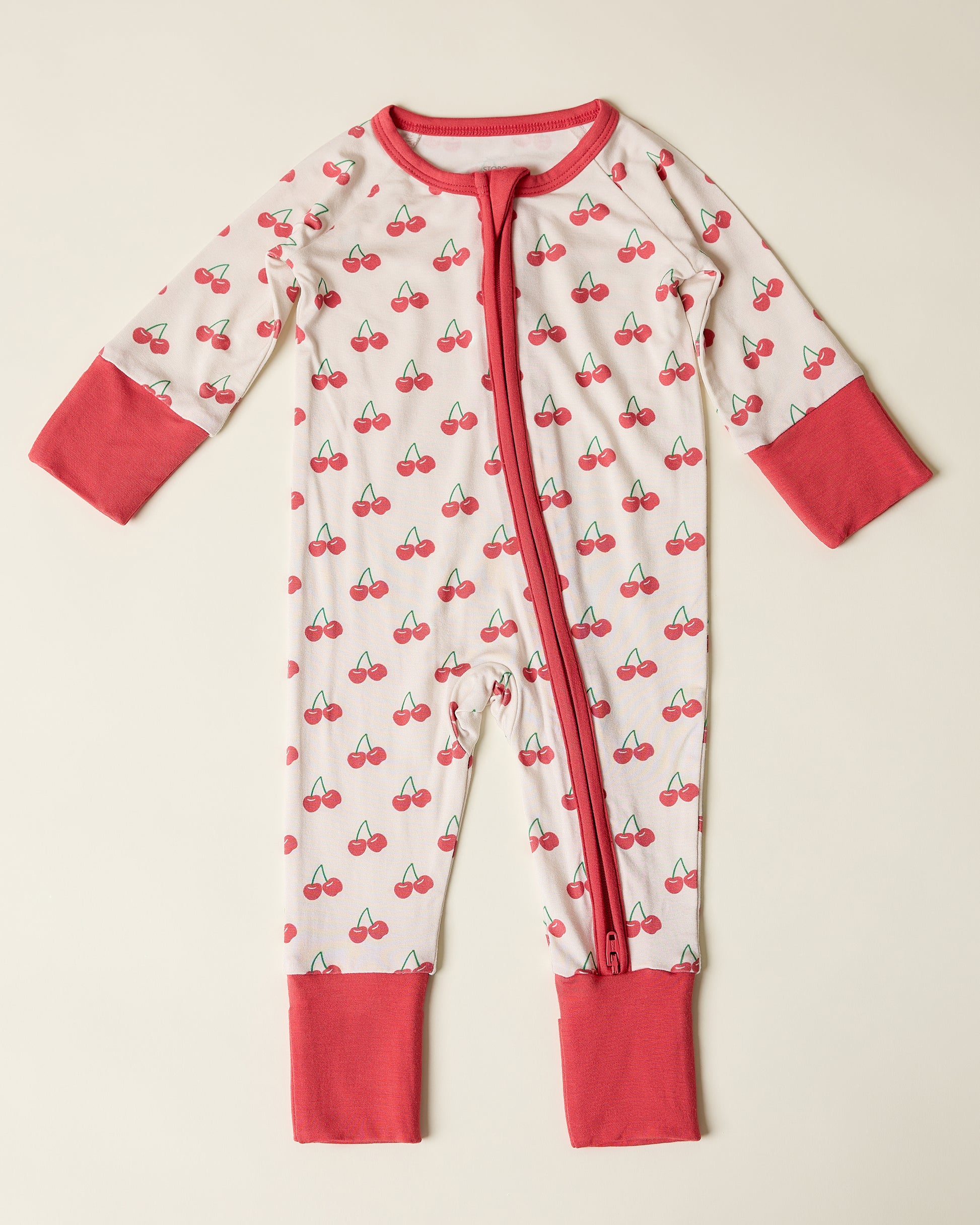 Bamboo Baby Pajama with cherry pattern on a beige background