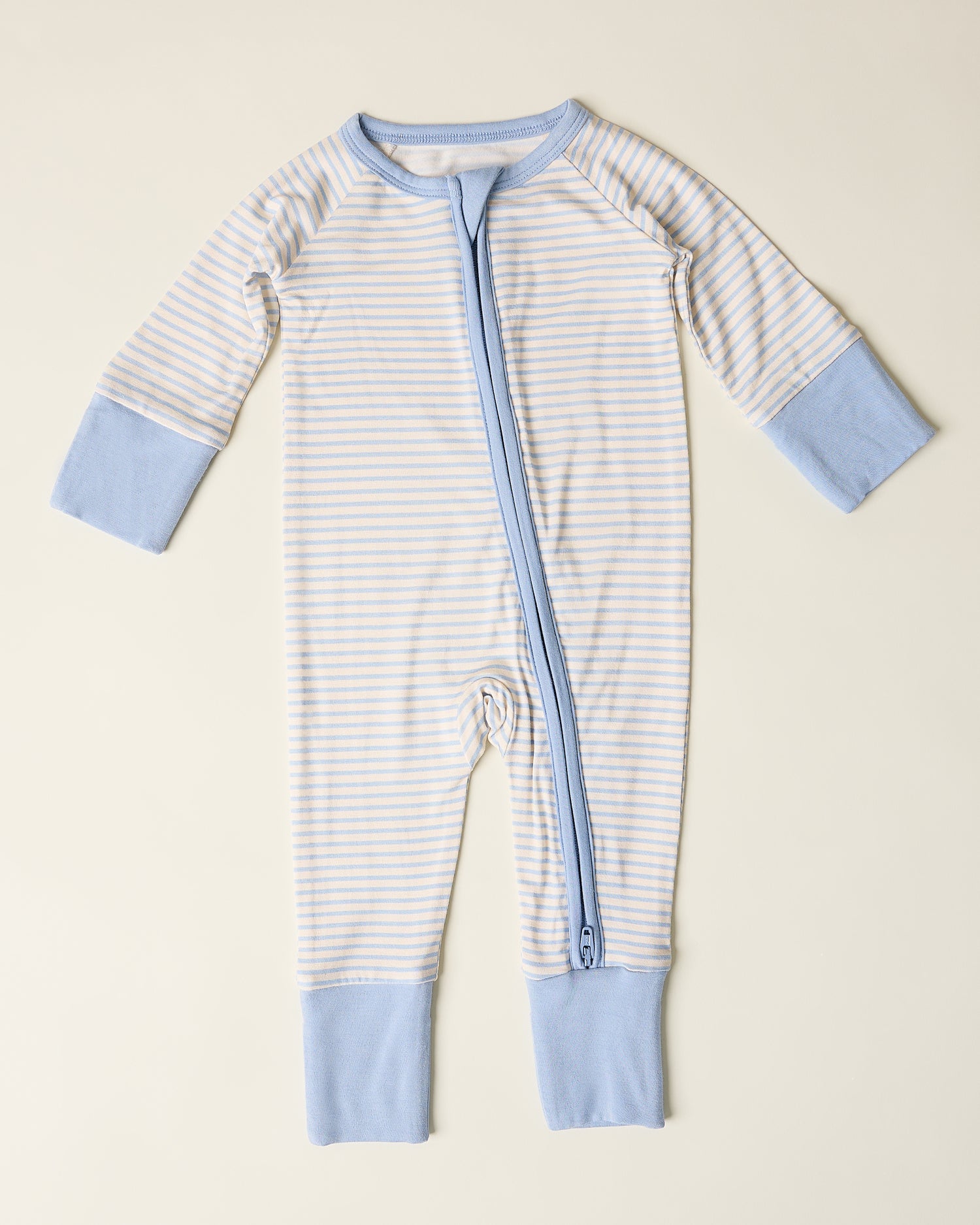 Bamboo Baby Pajama with blue candy stripe pattern on a beige background