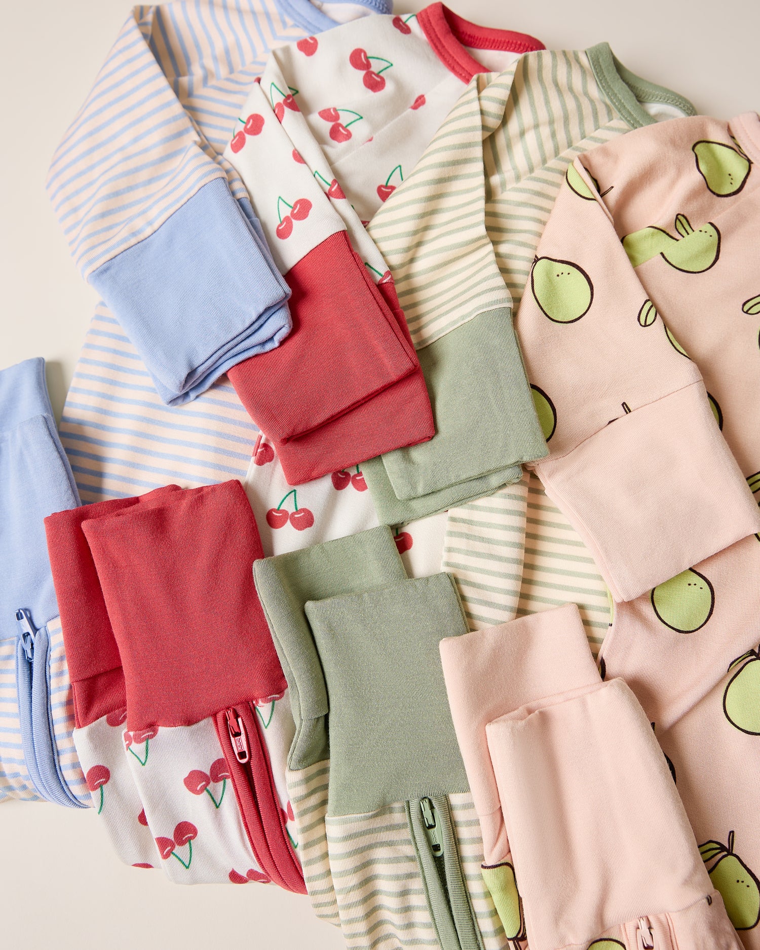 Collection of colorful children's pajamas with various patterns on a light background