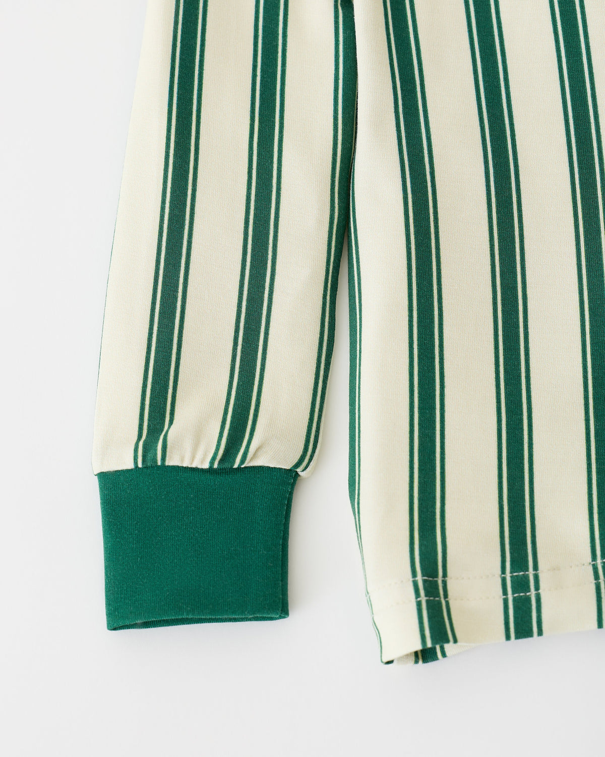 Close up of sleeve detail on Bamboo Baby Two-Piece Pajama Set in Green Candy Stripe on an off white background.