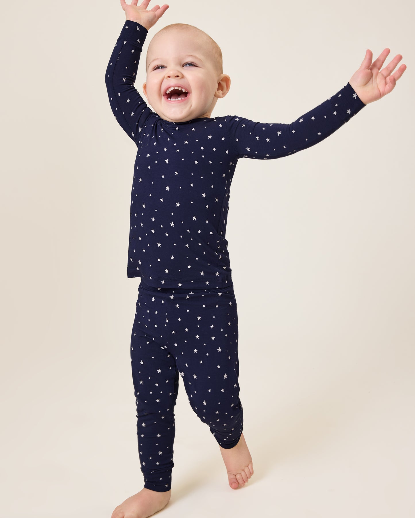 Baby laughing wearing the Bamboo Baby Two-Piece Pajama Set in Navy Stars print@model_info:Clark is wearing 18-24 months.