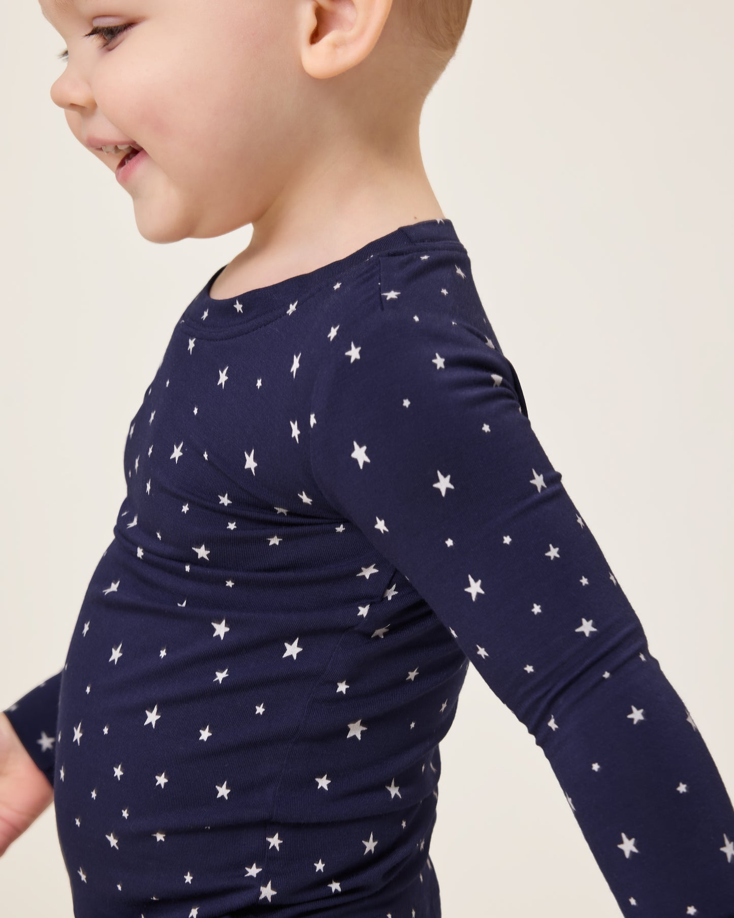 Baby looking down wearing the Bamboo Baby Two-Piece Pajama Set in Navy Stars print