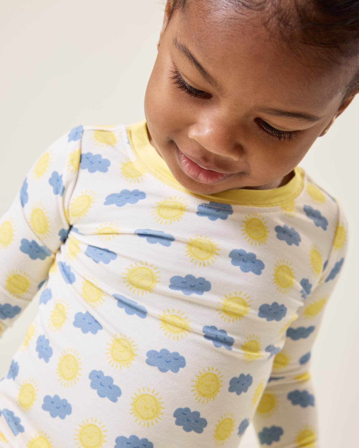 Baby looking down wearing the Bamboo Baby Two-Piece Pajama Set in Sunny Day print