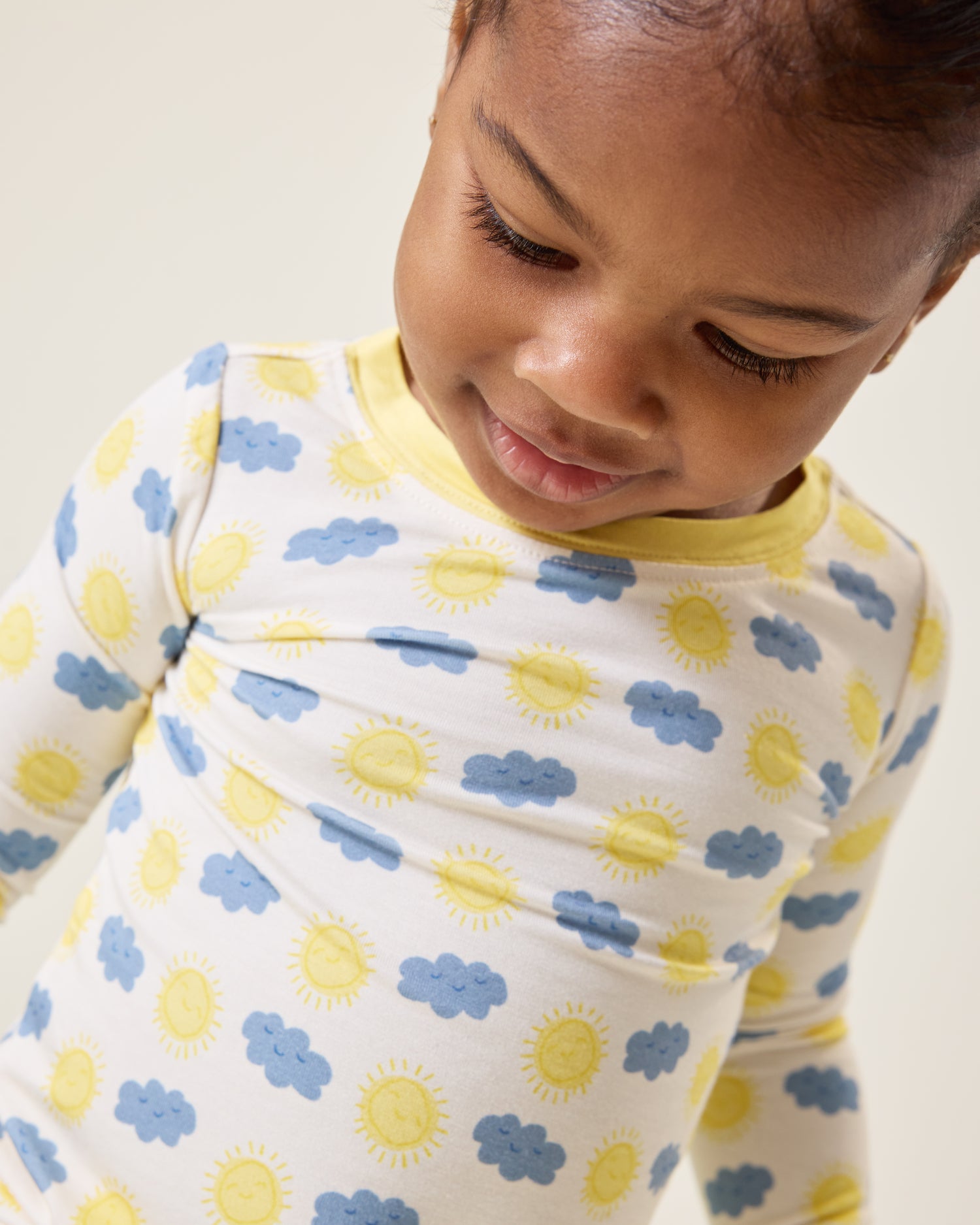 Baby looking down wearing the Bamboo Baby Two-Piece Pajama Set in Sunny Day print