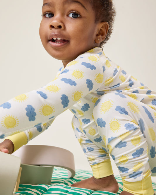 Baby playing and wearing the Bamboo Baby Two-Piece Pajama Set in Sunny Day print