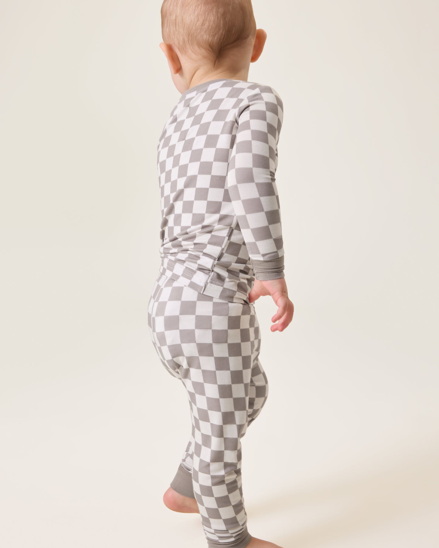 Baby wearing the Bamboo Baby Two-Piece Pajama Set in Taupe Checker print