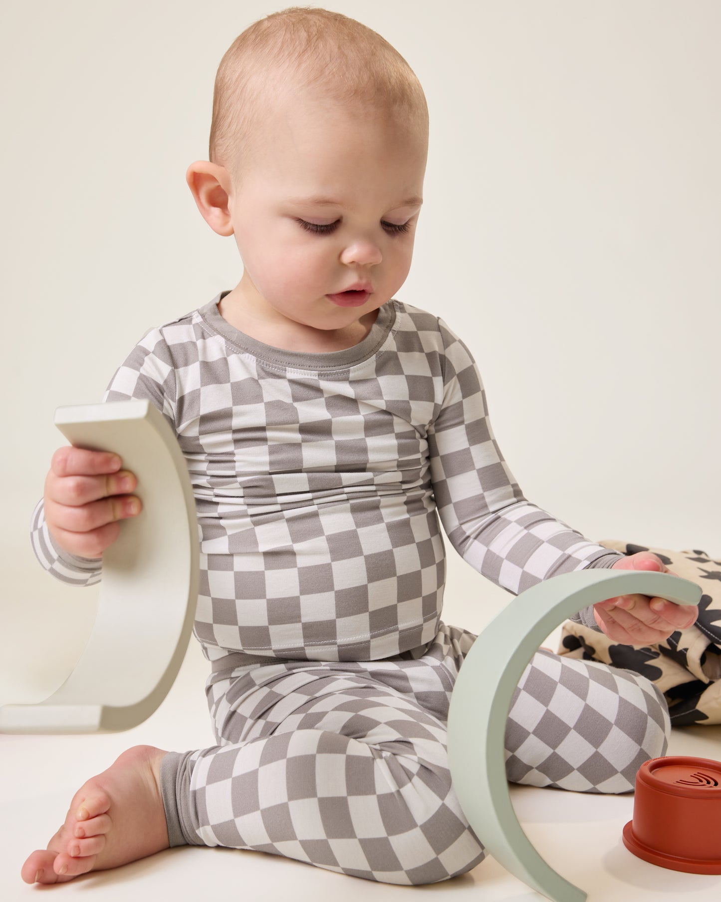 Baby playing with blocks wearing the Bamboo Baby Two-Piece Pajama Set in Taupe Checker print