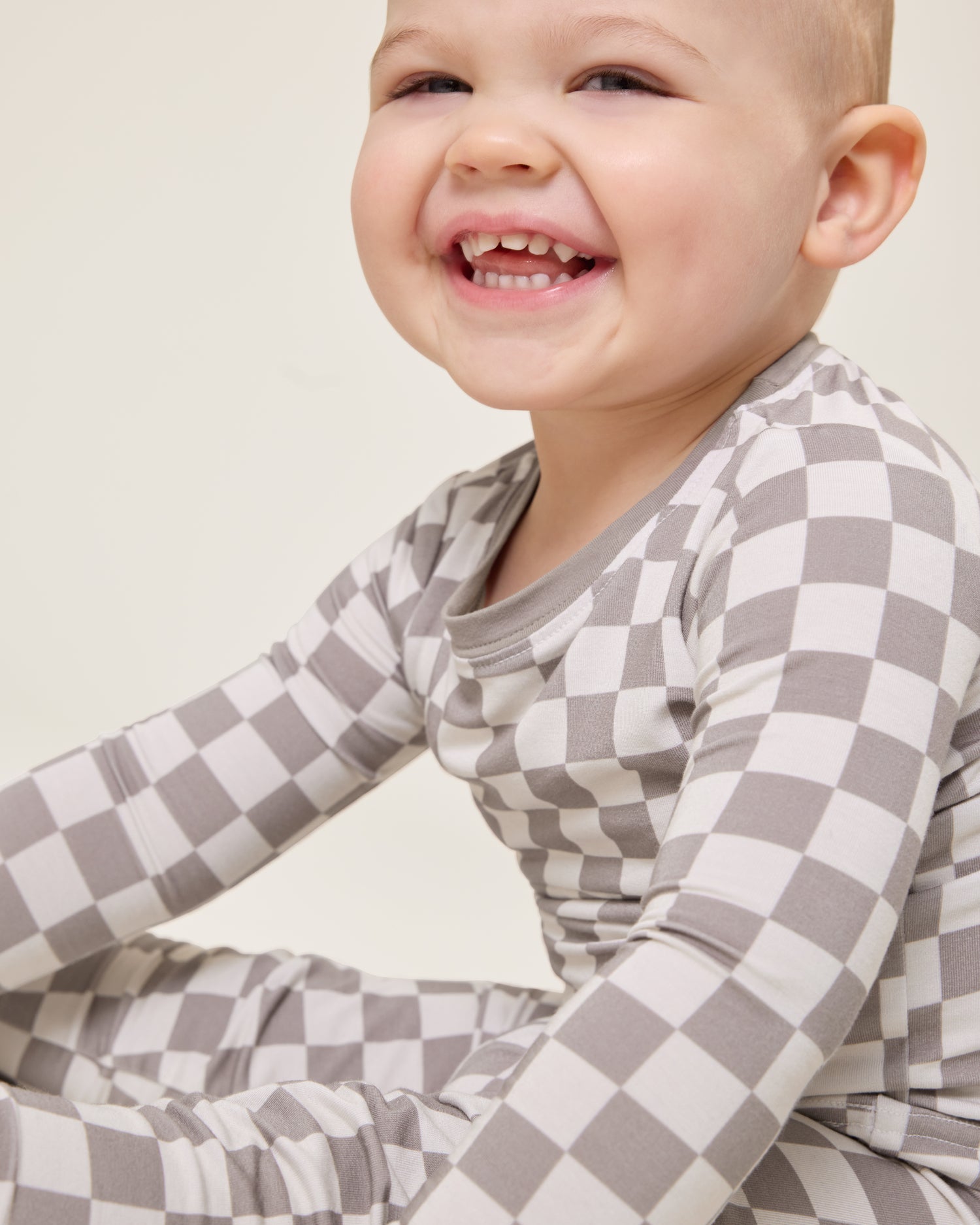 Baby wearing the Bamboo Baby Two-Piece Pajama Set in Taupe Checker print@model_info:Clark is wearing 18-24 months.