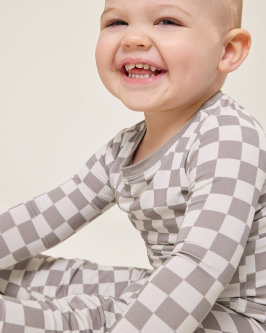 Baby wearing the Bamboo Baby Two-Piece Pajama Set in Taupe Checker print@model_info:Clark is wearing 18-24 months.