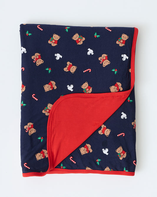Bamboo Blanket in Bearing Gifts folded to show red reversible design, on an off white background.