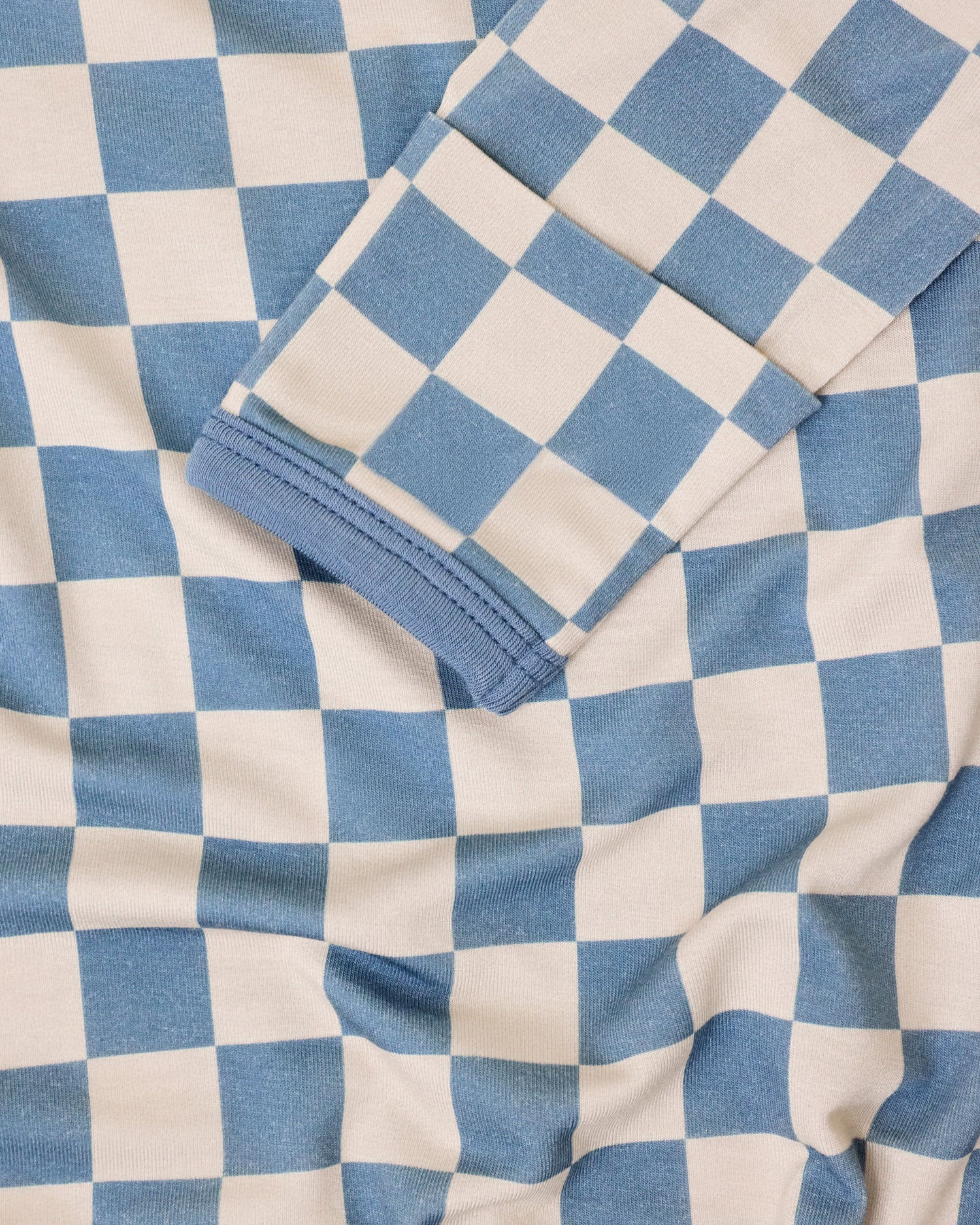 Close up of Bamboo Knotted Baby Gown & Hat in Blue Checker print on a neutral background