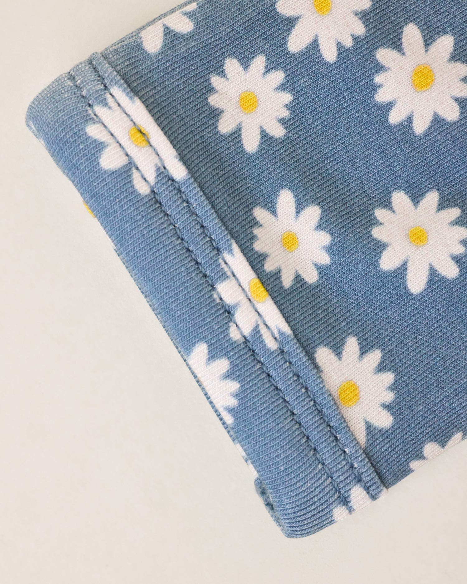 Close up of Bamboo Knotted Baby Gown & Hat in Blue Daisies print, showing a sleeve detail
