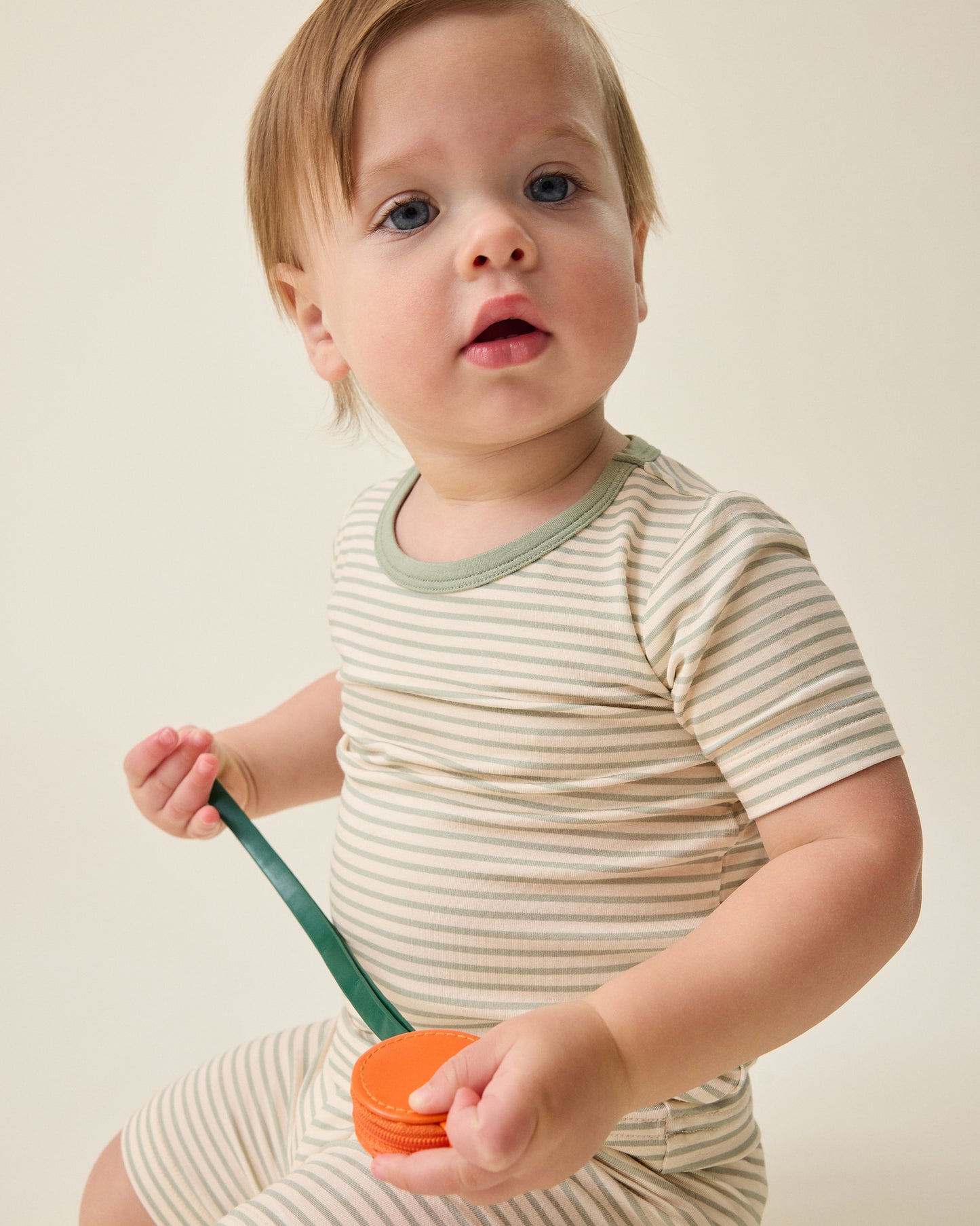 Child wearing the Bamboo Short Sleeve & Shorts Set in sage green stripe@model_info:Noa is wearing 6-12 months.