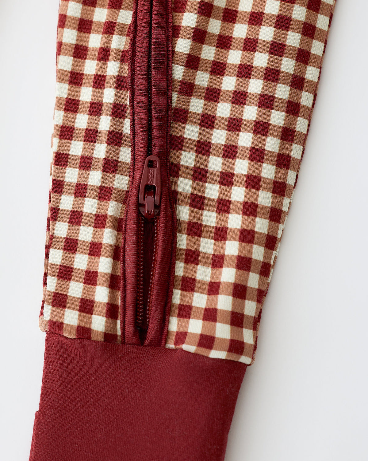 Close up of pant detail on Bamboo Baby Pajama in Auburn Gingham on an off white background.