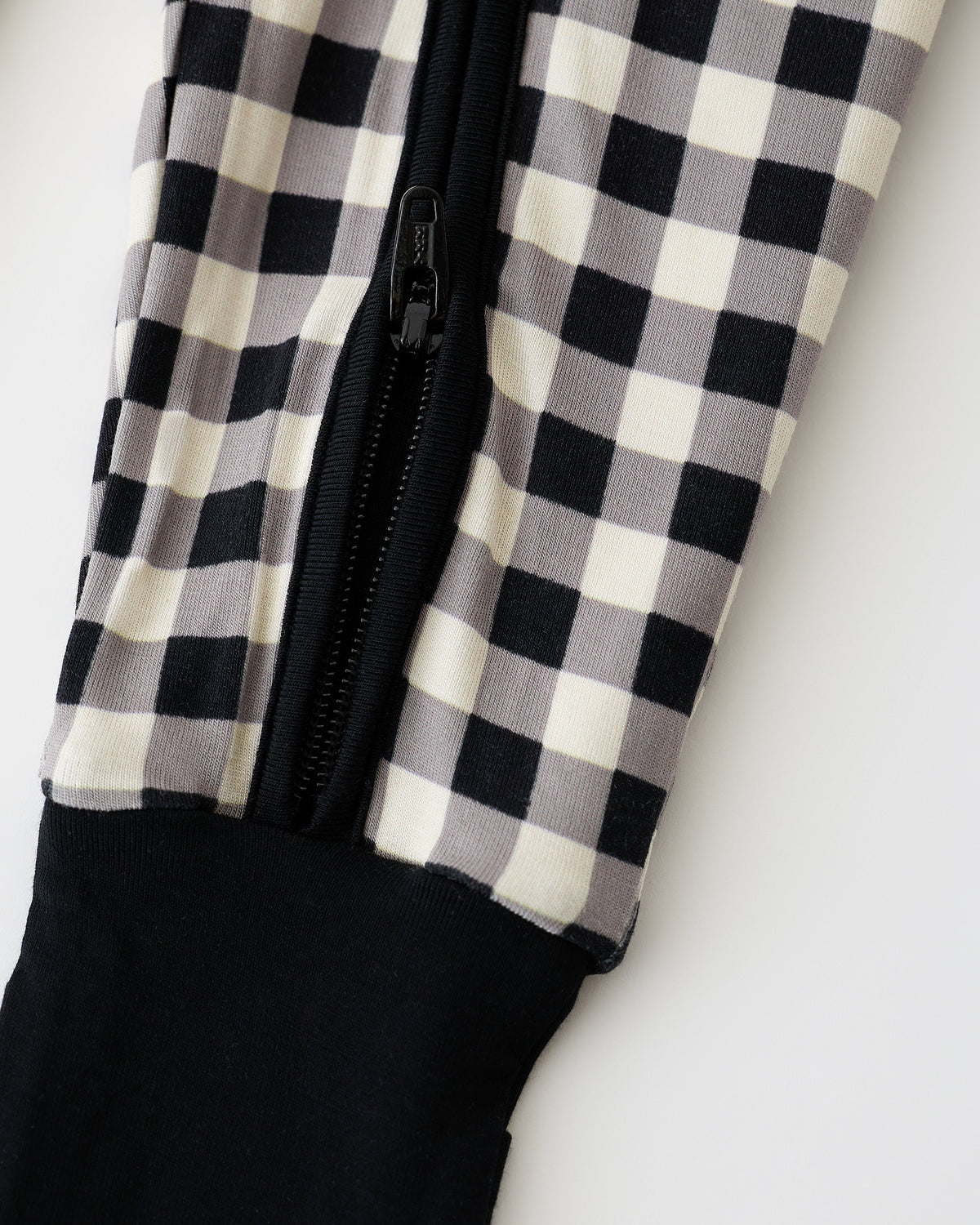 Close up of pant detail on Bamboo Baby Pajama in Black Gingham on an off white background.