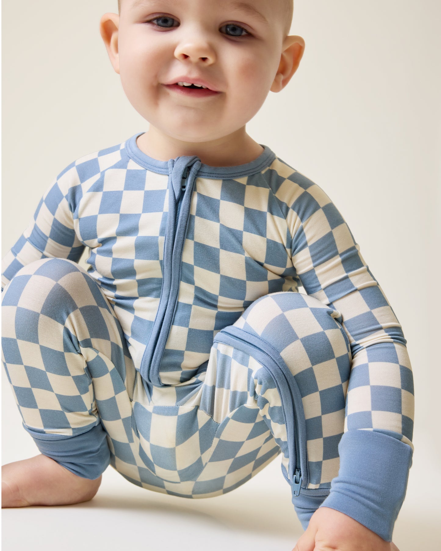 Baby squatting wearing the Bamboo Baby Pajama in Blue Checker print