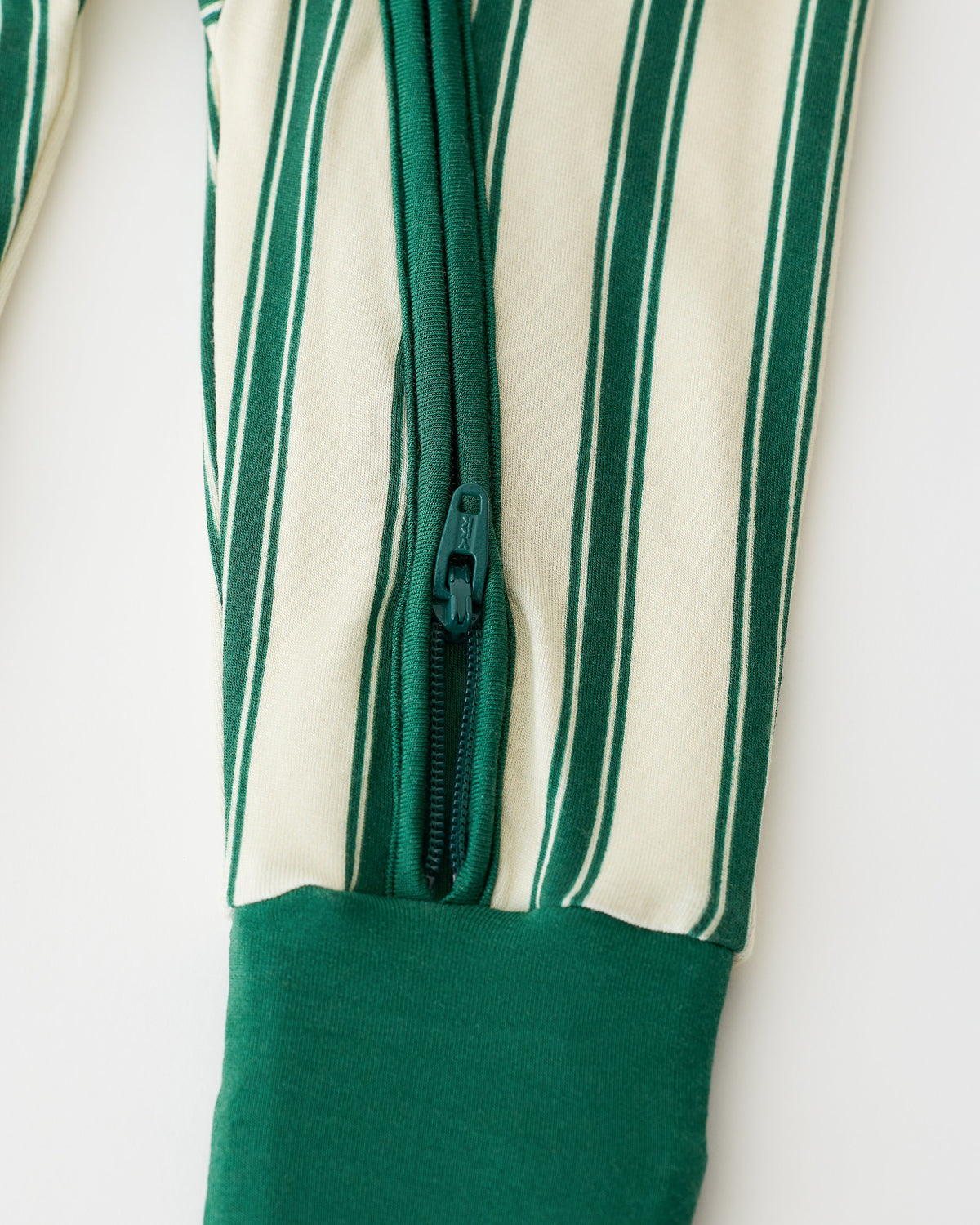 Close up of pant detail on Bamboo Baby Pajama in Green Candy Stripe on an off white background.