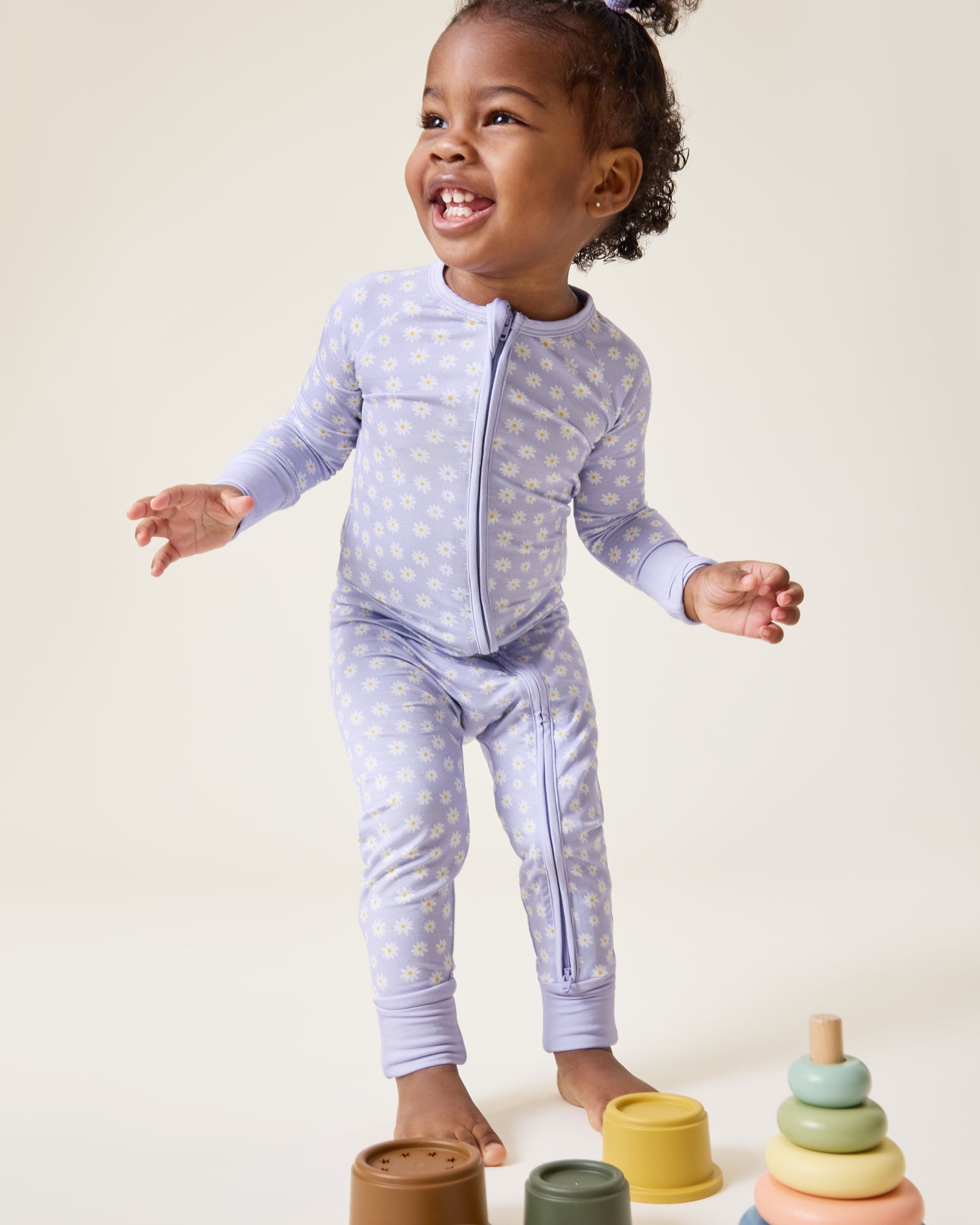 Baby playing, wearing the Bamboo Baby Pajama in Purple Daisies print