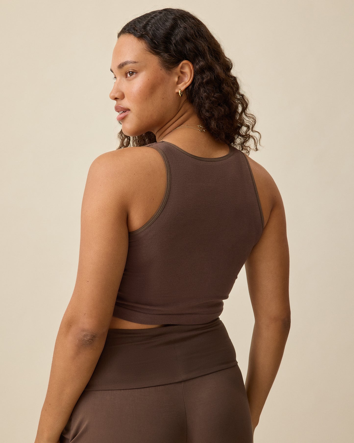 Model wearing Sublime® Bamboo Maternity & Nursing Longline Bra Top in Chocolate, displaying back view, on a beige background