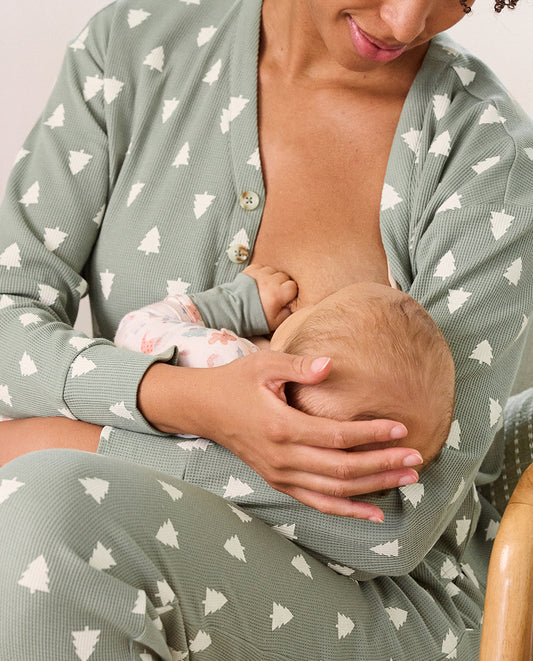 Person wearing the Waffle Lounge Set in Sage Trees nursing baby who is wearing the Bamboo Baby Pajama in a holiday print with sage trim
