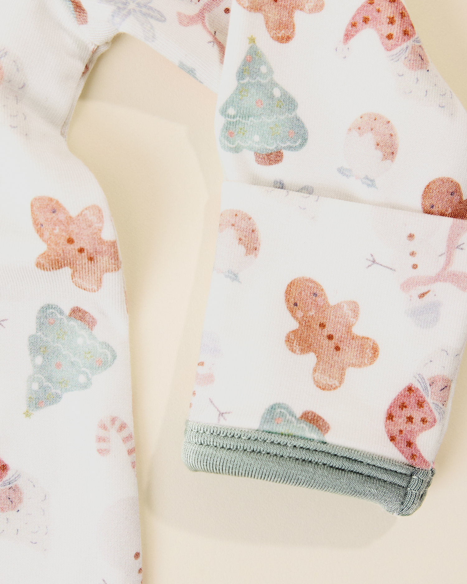 The Cozy Bamboo Baby Gown & Hat in Cozy Holiday pattern - gingerbread men, Christmas trees, candy canes, Santa, snowmen, showing foldover cuff detail
