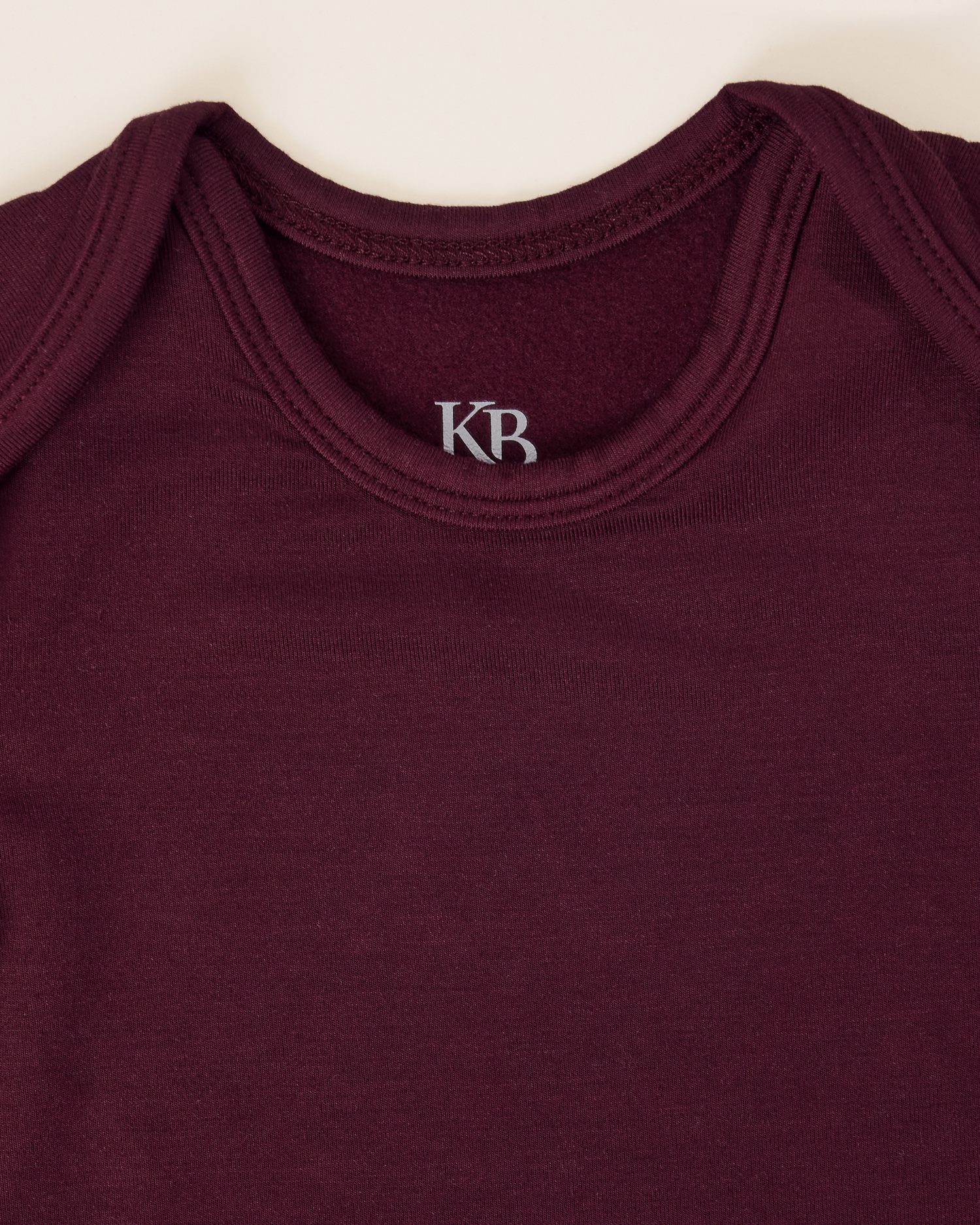 Close up of neckline on the Cozy Bamboo Baby Gown & Hat in Deep Burgundy