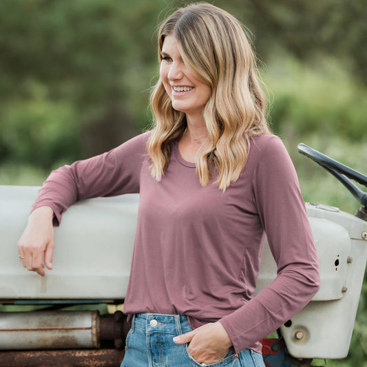 Model wearing the Bamboo Maternity & Nursing Long Sleeve T-shirt in Twilight with her hand on a car. @model_info:Amber is wearing a Small.