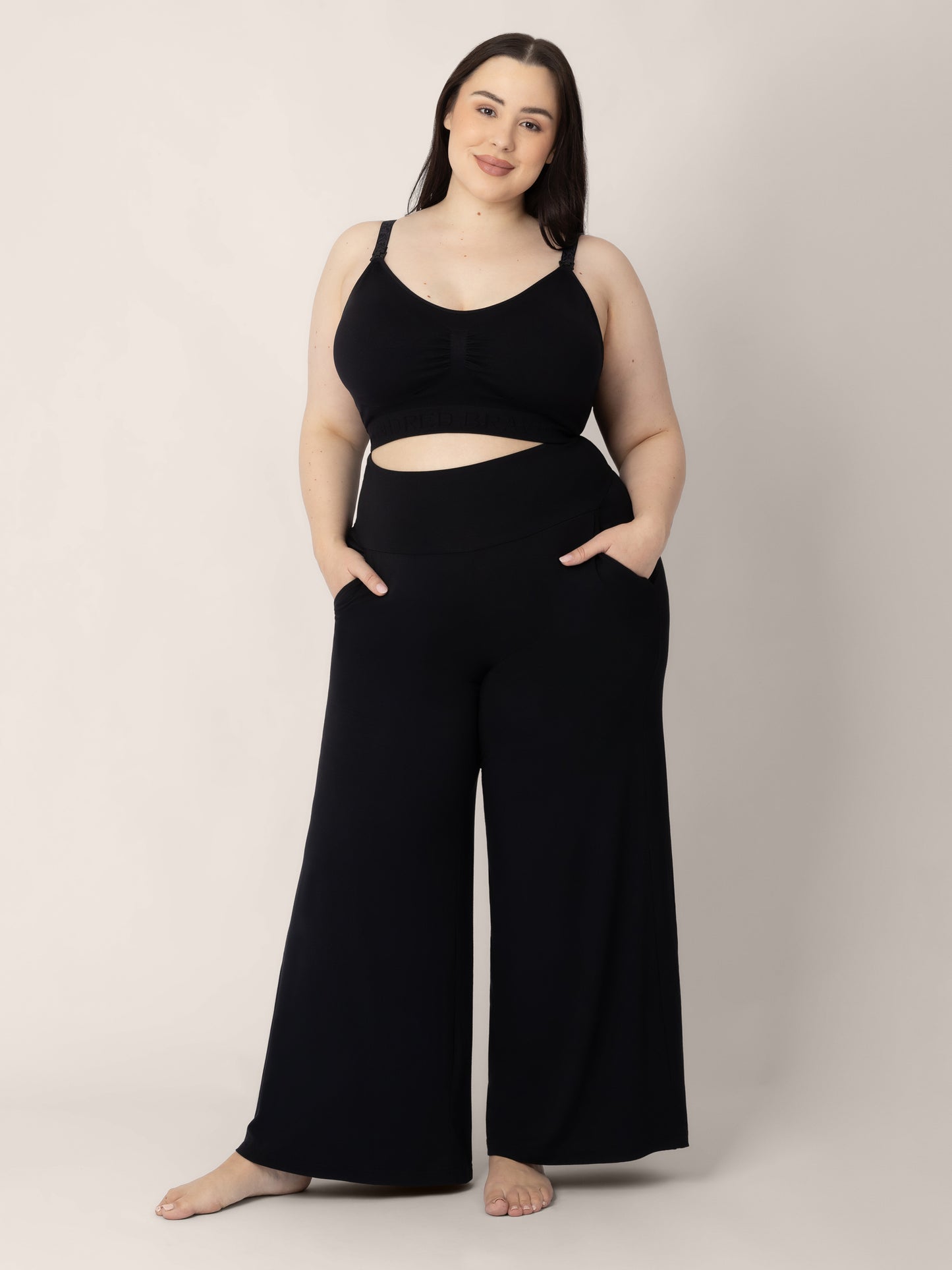Pregnant model wearing the Bamboo Wide Leg Maternity & Postpartum Lounge Pant in black, along with Sublime® Hands-Free Pumping & Nursing Sports Bra in black