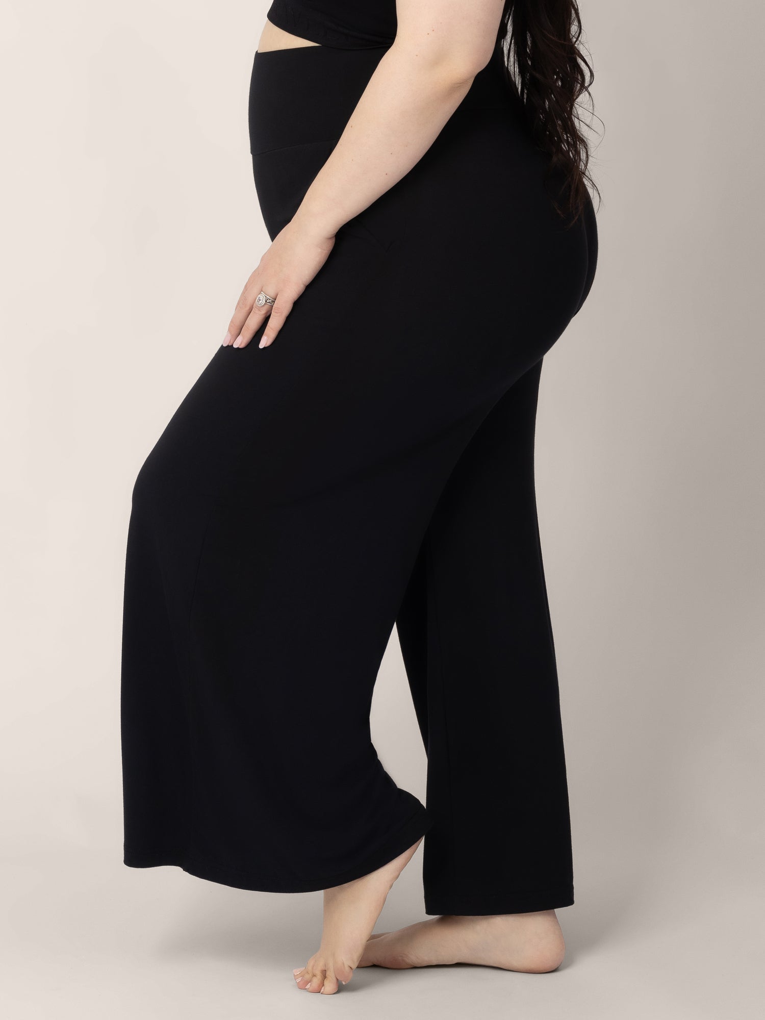 Bottom half of a pregnant model wearing the Bamboo Wide Leg Maternity & Postpartum Lounge Pant in Black